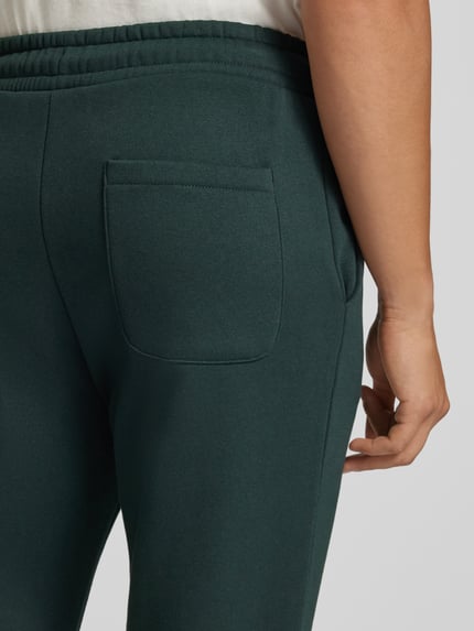 Männermodel trägt Straight Fit Sweatpants Modell 'BRADLEY' von JACK & JONES in Dunkelgrün, Baumwoll-Mix, Nahaufnahme Rückansicht. Material-Mix, elastischer Bund mit Tunnelzug, Innenbeinlänge bei Größe M 77 cm.