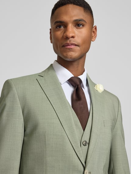 Męski model nosi Slim Fit 2-Knopf-Sakko mit Pattentaschen Modell 'Paul SV' od CG - Club of Gents, jasnozielony, drobna faktura, krój slim fit, klapy z wyłogiem, długość tyłu w rozmiarze 50: 77 cm, szerokość ramion w rozmiarze 50: 43 cm, długość rękawa w rozmiarze 50: 64 cm, zbliżenie na górną część tułowia