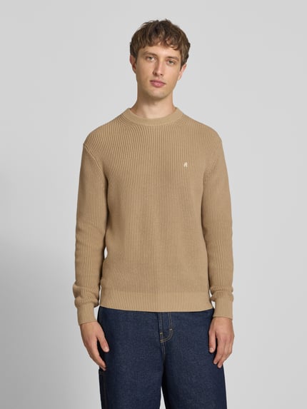 Männermodel trägt Slim Fit Pullover aus reiner Baumwolle in Strick-Optik von Replay in Beige, sichtbares Logo-Stitching, Ganzkörperansicht von vorne
