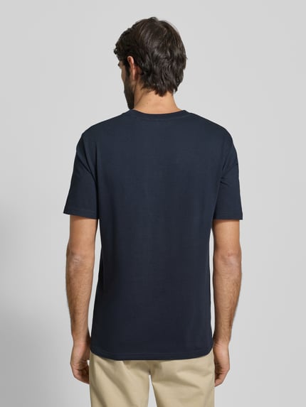 Männermodel trägt T-Shirt mit Label-Print von MARC O’POLO, gerade geschnitten, unifarben, reine Baumwolle, Rückenansicht, Ganzkörperansicht.