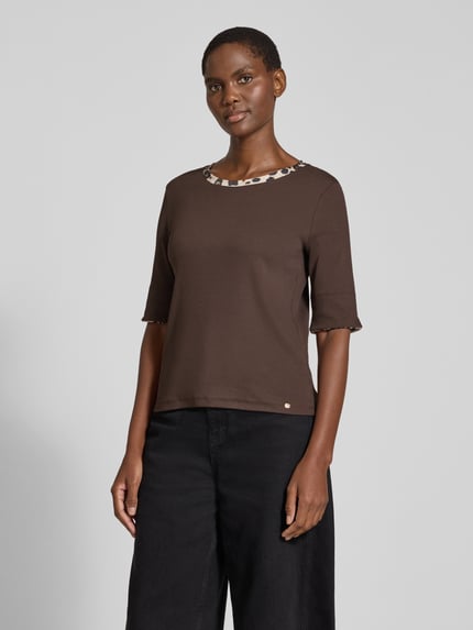 Frauenmodel trägt T-Shirt mit kontrastierendem Ausschnitt von MARC CAIN in Braun, unifarben, Animal-Print am Rundhalsausschnitt, Jersey, 1/2-Arm, geschlitzter Saum, Ganzkörperansicht von vorne.