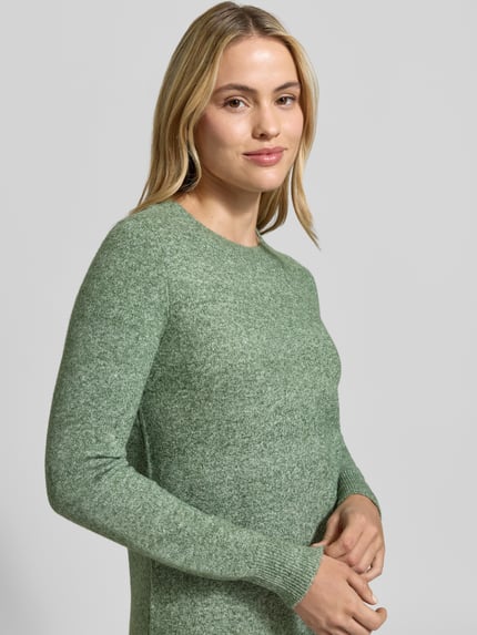 Frauenmodel trägt Tailliertes Strickkleid mit Rundhalsausschnitt Modell 'DOFFY' von VERO MODA, Melange-Optik, grün, Regular Fit, Mini, Nahaufnahme Oberkörper.