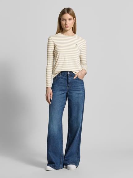 Frauenmodel trägt Longsleeve mit Label-Stitching von Gant in creme-weiß gestreift, Reine Baumwolle, Regular-Fit, Rundhalsausschnitt, Damen Longsleeve, Rückenlänge bei Größe S: 54 cm, Ganzkörperansicht von vorne.