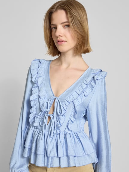 Frauenmodel trägt Regular Fit Langarmbluse aus Viskose-Mix Modell 'ZOEY' von Vero Moda, Optik: Unifarben, Rüschen-Detail, Nahaufnahme Oberkörper