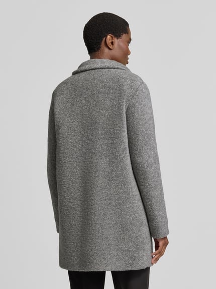 Frauenmodel trägt Regular Fit Mantel mit Baumwoll-Schrwoll-Anteil von FUCHS SCHMITT in Grau, strukturierte Oberfläche, Ganzkörperansicht Rückansicht. Rückenlänge 82 cm, Schulterbreite 42 cm, Brustweite 51 cm, Ärmellänge 64 cm.