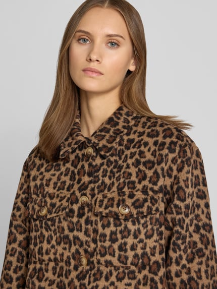 Frauenmodel trägt Oversized Hemdjacke mit Umlegekragen Modell 'SAGA' von PIECES, braunes Leopardenmuster, Nahaufnahme Oberkörper. Damen Hemdjacke von PIECES.