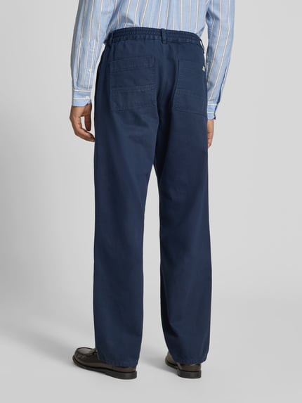 Männermodel trägt Jeans mit elastischem Bund von Forét aus bawełna, krój straight fit, kieszenie z tyłu, ciemnoniebieski, Ganzkörperansicht Rückansicht