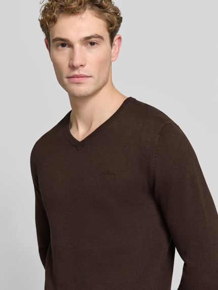 Männermodel trägt Pullover mit Logo-Stitching von S.OLIVER CASUAL in Dunkelbraun, Strukturmuster, V-Ausschnitt, Nahaufnahme Oberkörper.
