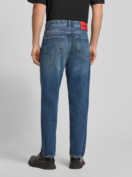 Männermodel draagt Relaxed Fit Jeans uit puur katoen Model 'HUGO 838' van HUGO, effen look, 5-pocketmodel, labelpatch, denim, volledige achteraanzicht.