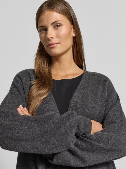 Frauenmodel trägt Strickjacke aus Lanawolle-Kaschmir-Mix Modell 'CESTINO' von Max Mara, dunkelgrau, lockere Passform, Nahaufnahme Oberkörper.