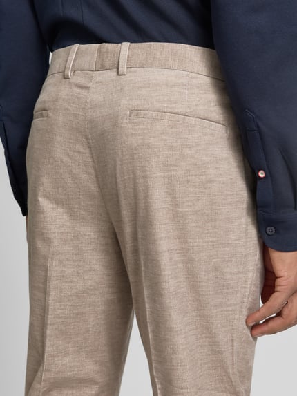 Männermodel trägt Regular Fit Anzughose mit Bundfalte von S. OLIVER BLACK LABEL in Beige, Feincord, unifarben, Detailaufnahme Rückansicht.