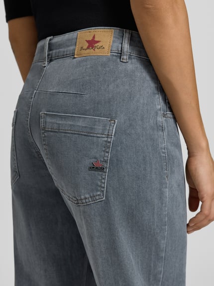 Frauenmodel trägt Regular Fit Barrel Jeans mit Bundfalte von BUENA VISTA, grauer Denim in Medium Wash und Used Look, Detailaufnahme Rückansicht.