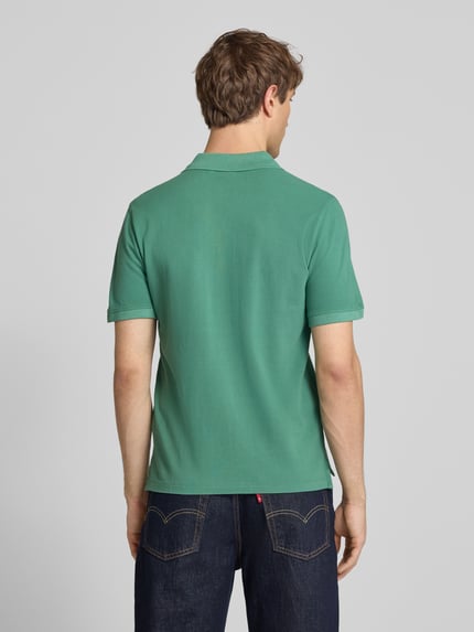 Männermodel trägt Regular Fit Poloshirt aus reiner Baumwolle Modell 'OSCAR' von Pepe Jeans, grün, Optik: Unifarben, Ganzkörperansicht Rückansicht.