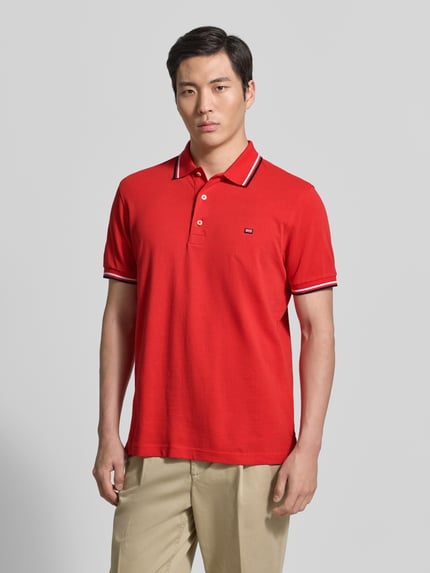 Męski model nosi Regular Fit Poloshirt mit Kontraststreifen od Christian Berg Men, czysta bawełna, czerwony, krój regular fit, listwa guzikowa, długość tyłu 71 cm w rozmiarze M, całkowity widok z przodu.