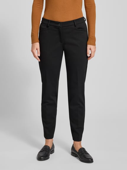 Frauenmodel trägt Hose mit elastischem Bund und Bügelfalten Modell 'MARON' von Brax, schwarzer Material-Mix mit Viskose-Anteil, verkürzte Passform, Ganzkörperansicht von vorne.