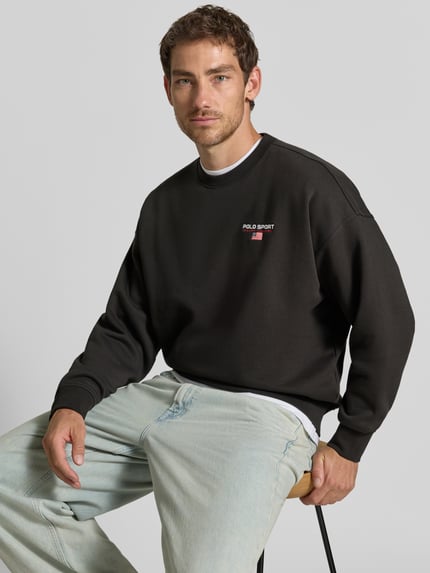 Männermodel trägt Relaxed Fit Sweatshirt aus Baumwoll-Mix von Polo Ralph Lauren in Schwarz mit kleinem Logo, Nahaufnahme Oberkörper.