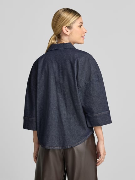 Vrouwenmodel draagt Relaxed Fit jeansblouse uit katoenmix van Tom Tailor in donkerblauw, gladde structuur, volledige rugaanzicht. Dames jeansblouse van Tom Tailor
