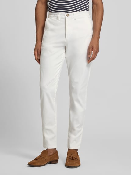 Männermodel trägt Slim Fit Chino aus Baumwoll-Mix von SELECTED HOMME, Optik: Unifarben, Passform: Slim-Fit, Farbe Weiß, Nahaufnahme Unterkörper.