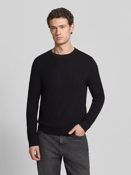 Männermodel trägt Pullover mit Strukturstrickoptik aus reiner Baumwolle von S.OLIVER CASUAL, melierte Strickoptik, Rundhals, Ganzkörperansicht von vorne.