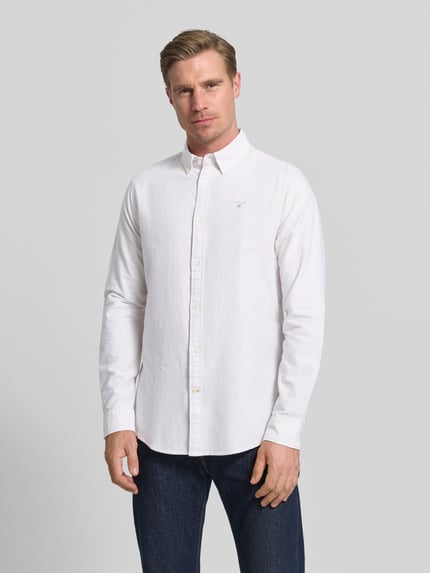 Männermodel trägt Barbour Tailored Fit Freizeithemd aus reiner Baumwolle Modell 'STRIPED OXFORD' in Weiß, Optik:Allover-Muster, Strukturmuster, Button-Down-Kragen, durchgehende Knopfleiste, Label-Stitching, Langarm, Sportmanschette, Materialverarbeitung: Oxford, Ganzkörperansicht von vorne.