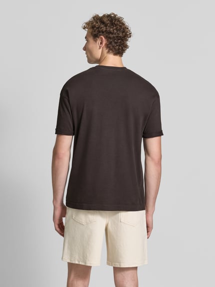 Männermodel trägt Regular Fit T-Shirt aus reiner Baumwolle Modell 'Thilo' von DRYKORN in Dunkelbraun, kurze Ärmel, Ganzkörperansicht Rückansicht.