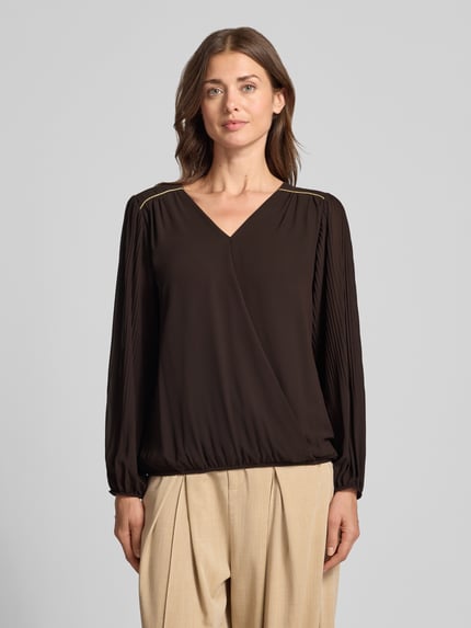 Frauenmodel trägt Bluse mit V-Ausschnitt Modell 'Be44rtaa' von ZABAIONE, braun, gerade Form, elastische Abschlüsse, Ganzkörperansicht von vorne.