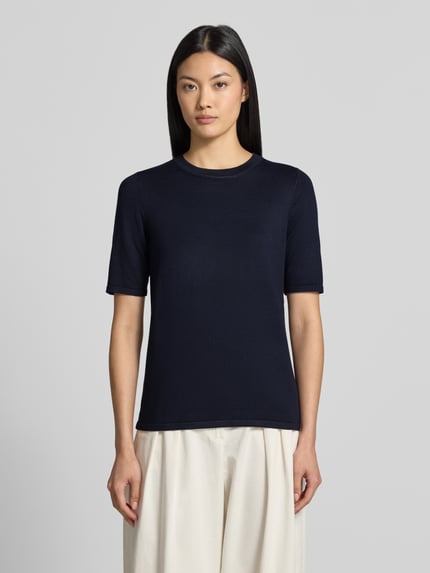 Frauenmodel trägt Regular Fit Pullover in Strick-Optik Modell "LULS" von ICHI, Viskose-Mix, kurzärmelig, navyblau, Rundhalsausschnitt, Ganzkörperansicht von vorne.