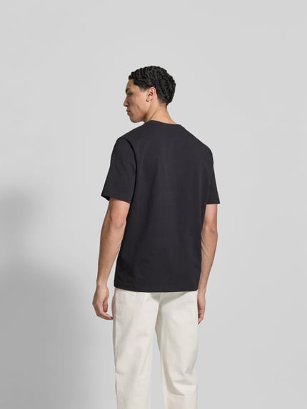Mężczyznamodel nosi Regular Fit T-Shirt aus Baumwolle od MAISON KITSUNÉ; czarny kolor, krój regular fit, widok całej sylwetki z tyłu.