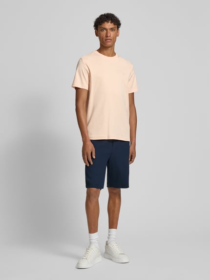 Männermodel trägt Shorts mit Eingrifftaschen Modell 'Joseignacio' van JOOP! Collection in loose fit, katoenmix, donkerblauw, elastische tailleband, Franse steekzakken, label-patch, maat M, midden van voren, Ganzkörperansicht von vorne.