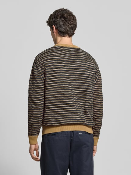 Männermodel trägt Cardigan mit Logo-Applikation von Lacoste, mehrfarbiges geometrisches Jacquard-Muster, Strickoptik, Ganzkörperansicht Rückansicht