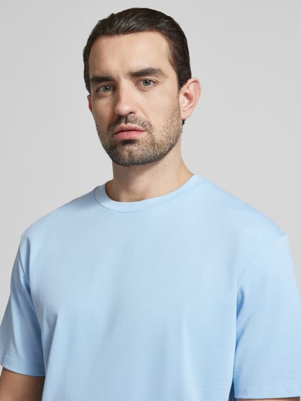 Männermodel trägt Oversized T-Shirt mit Rundhalsausschnitt von Lindbergh in Hellblau, reine Baumwolle, Nahaufnahme Oberkörper.