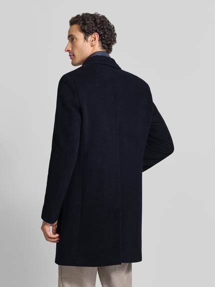 Männermodel trägt Mantel mit herausnehmbarer Steppweste von BOSS in dunklem Uni-Ton, Struktur, Longline, Rückansicht, Webware.