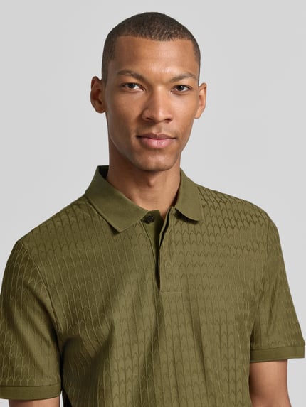 Männermodel trägt olivgrünes Regular Fit Poloshirt aus reiner Baumwolle Modell 'Parley 321' von BOSS, Nahaufnahme Oberkörper, Herren Poloshirt von BOSS.
