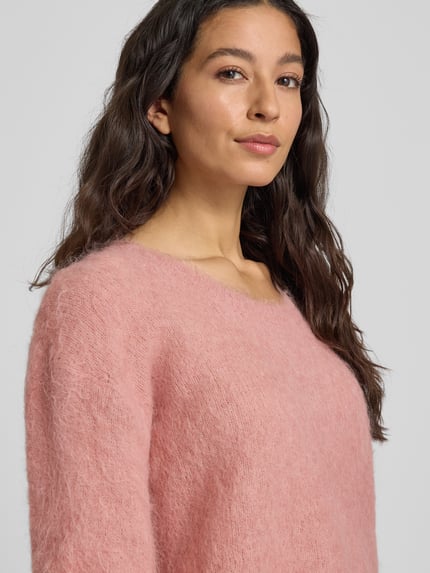 Kobiece model prezentuje Strickpullover mit gerippten Abschlüssen Modell 'NUNY' von American Vintage w różowym kolorze, z okrągłym dekoltem, luźny krój, mieszanka materiałów ze stretchem, tekstura puszysta; zbliżenie na górną część ciała.