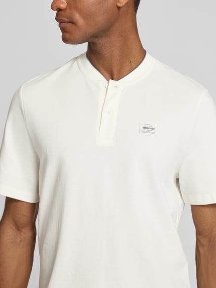Männermodel draagt Regular Fit Poloshirt aus katoenmix van s.Oliver RED LABEL, look: effen, labelpatch, henley-hals, 2-knoopsluiting, korte mouw, piqué materiaalverwerking, Nahaufnahme Oberkörper.