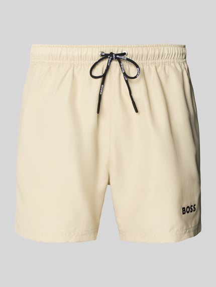 Produktfoto, cremefarbene Badeshorts mit Label-Applikation Modell 'DOGFISH' von BOSS, unifarbene Optik, elastischer Bund, Regular Fit, seitliche Eingrifftaschen und Gesäßtasche, strukturierte Textur.
