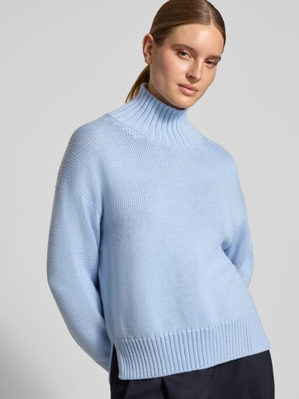 Frauenmodel trägt Strickpullover aus Woll-Mix mit Stehkragen von Closed in Hellblau, gerippte Abschlüsse, Loose Fit, Nahaufnahme Oberkörper.
