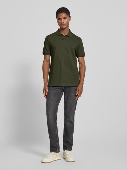 Männermodel trägt Regular Fit Poloshirt aus reiner Baumwolle von s.Oliver RED LABEL in Dunkelgrün, Ganzkörperansicht von vorne.