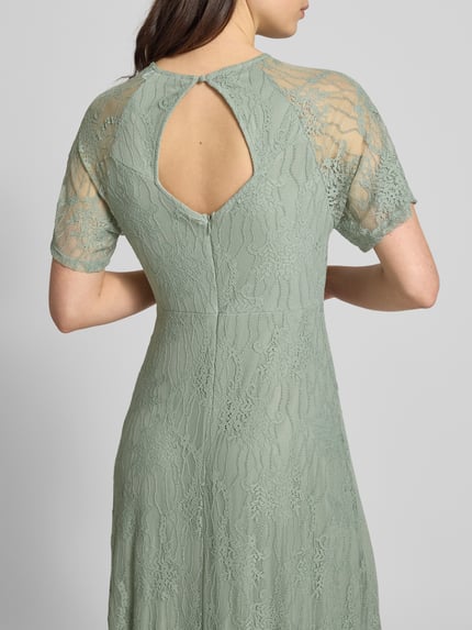 Vrouwenmodel draagt maxi-jurk uit kant met ronde hals model 'FEMMA' van Vila, materiaalmix met stretch, recht model, rugaanzicht