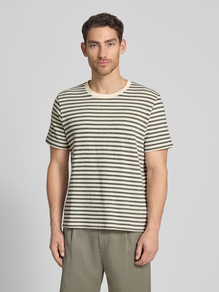 Männermodel trägt Regular Fit T-Shirt aus Baumwoll-Mix Modell 'KEVIN' von SELECTED HOMME mit Allover-Muster, gestreift, Rundhals, Kurzarm, Feinstrick, Ganzkörperansicht von vorne.