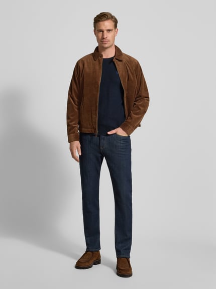 Männermodel trägt Strickpullover mit Label-Stitching von Polo Ralph Lauren in Marineblau, kombiniert mit Jeans, Ganzkörperansicht von vorne, Regular Fit aus reiner Baumwolle, gerippte Abschlüsse, Rundhalsausschnitt.