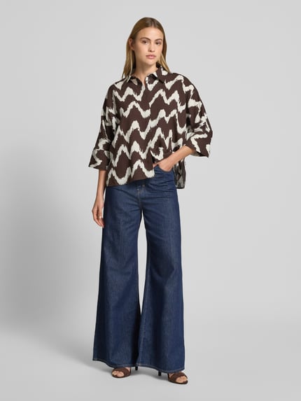 Frauenmodel trägt Bluse aus Viskose-Mix mit 3/4-Arm Modell 'FAWEN' von OPUS PANTS, braun-weiß gemustert, Ganzkörperansicht von vorne, Damen Bluse, Leinen-Viskose-Anteil, Straight Fit, Hemdblusenkragen, verdeckte Knopfleiste, Rückenlänge 60 cm, Ärmellänge 38 cm.