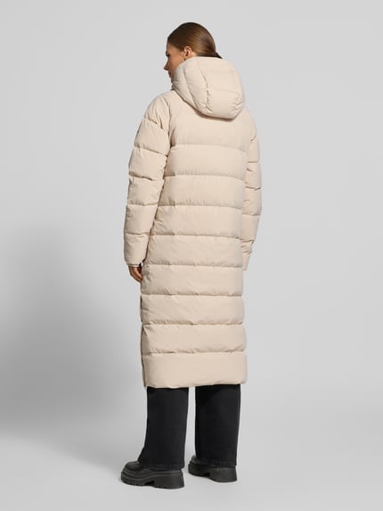 Männermodel trägt Steppmantel mit Kapuze Modell 'Amaze' von Columbia, beige, Baumwollmischung mit Stretch, krój regular fit, Ganzkörperansicht Rückansicht