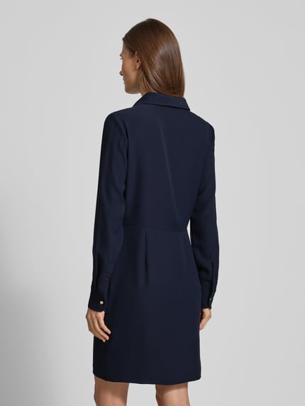 Vrouwenmodel draagt Mini-jurk met korte knoopsluiting van Lauren Ralph Lauren, getailleerd model, overhemdkraag, plooien, doornsluiting. Ganzkörperansicht Rückansicht. Ruglengte maat 36: 89 cm, borstwijdte: 39 cm, mouwlengte: 62 cm.