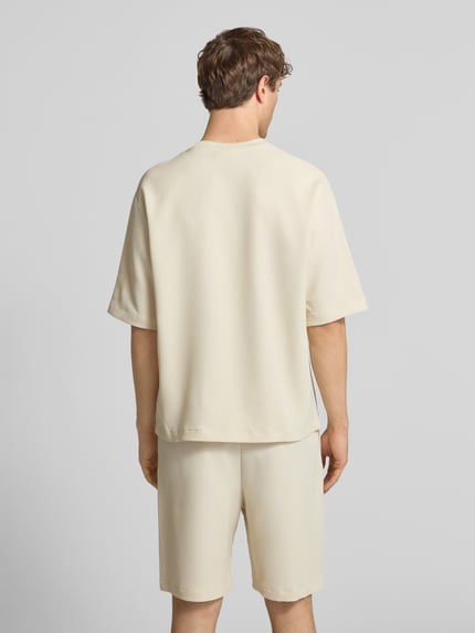 Männermodel trägt Regular-Fit T-Shirt in Plissee-Optik von REVIEW, Beige, Material-Mix mit Stretch-Anteil, Rückenlänge 68 cm, Ganzkörperansicht Rückansicht.