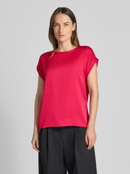 Frauenmodel trägt T-Shirt mit Rundhalsausschnitt Modell 'ELLETTE' von Vila, leuchtend pink, lockerer Schnitt, glatte Textur, Nahaufnahme Oberkörper.
