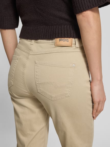 Frauenmodel trägt Hose in verkürzter Passform Modell 'Ornella' von Angels aus Baumwoll-Mix mit Stretch-Anteil, Eingrifftaschen, Bundweite 40 cm bei Größe 36, Detailaufnahme Rückansicht.