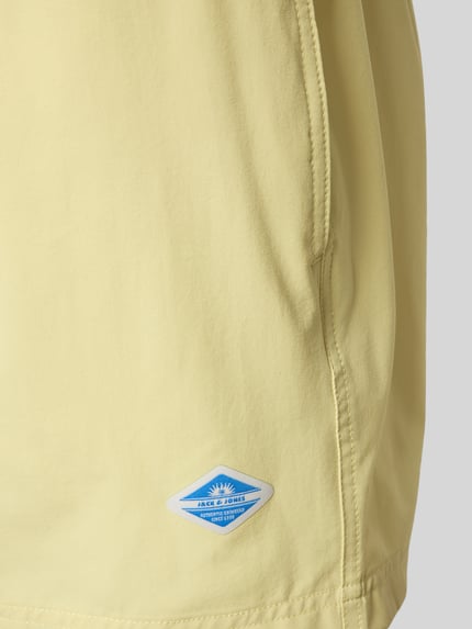 Produktfoto, Straight Fit Badeshorts mit Logo-Detail Modell 'Maui' von Jack & Jones in Hellgelb mit glatter Textur, elastischer Bund mit Tunnelzug. Herren Badeshorts.