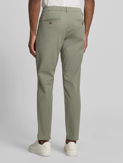 Männermodel draagt Slim Fit Chino aus Baumwoll-Mix Modell 'MILES' van Selected Homme in effen kleuren, katoenmix, achterzakken, riemlussen, knoop- en ritssluiting, look: effen, ganzkörperansicht rückansicht.