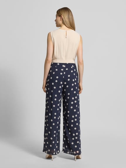 Frauenmodel trägt Regular Fit Jumpsuit mit Taillengürtel zum Binden von s.Oliver BLACK LABEL, Optik: Mehrfarbig, Muster: Gepunktet, Materialverarbeitung: Chiffon, U-Boot-Ausschnitt, ohne Ärmel, Reißverschluss, Ganzkörperansicht Rückansicht.